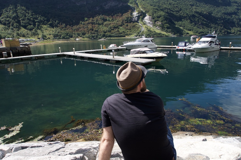 Geoff Matthews Wandertooth sits on the edge of Geiranger Fjord
