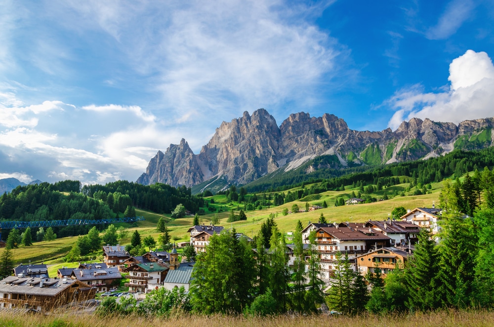 Amazing view on Cristallo Mountains with alpine village on sunny summer day, The Dolomites Mountains, Italy