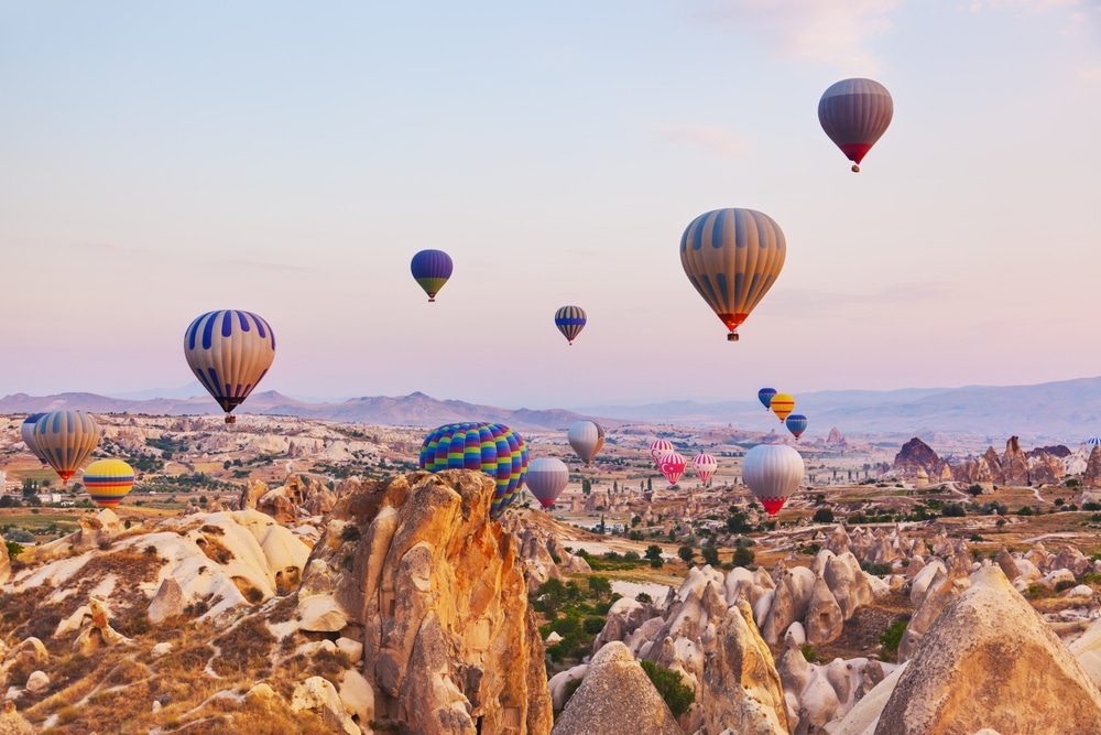 Hot air balloon flying over rock landscape at Cappadocia Turkey