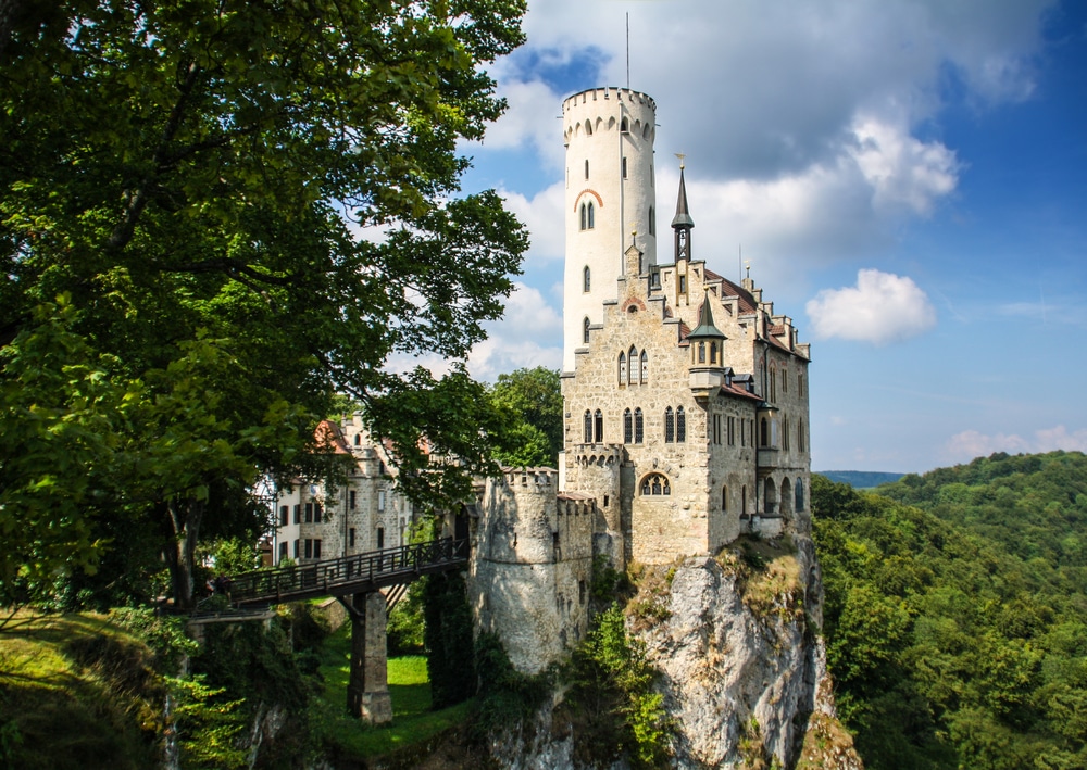 Lichtenstein castle in Germany—castle on edge of cliff overlooking forest