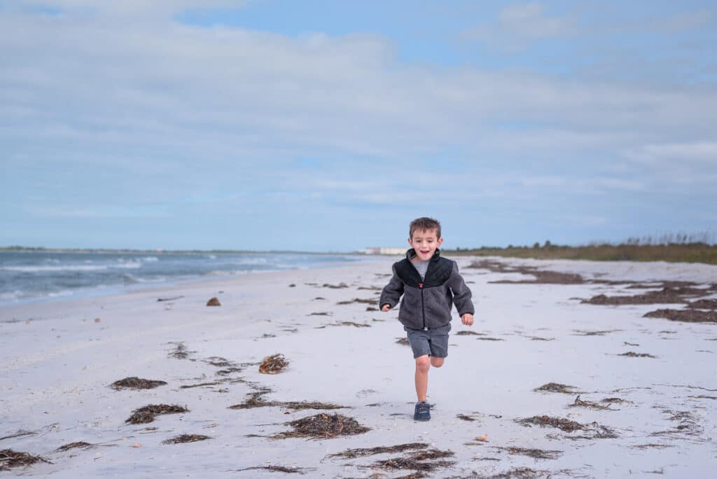 my son running on the beach at caladesi island