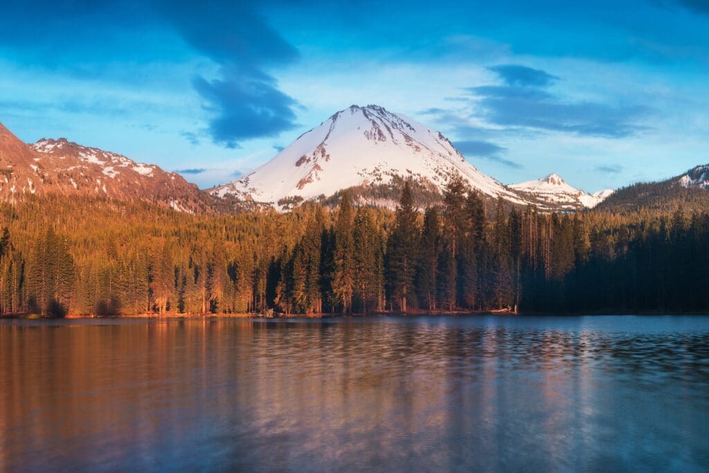 snow covered volcano overlooking lake in Lassen volcanic national park