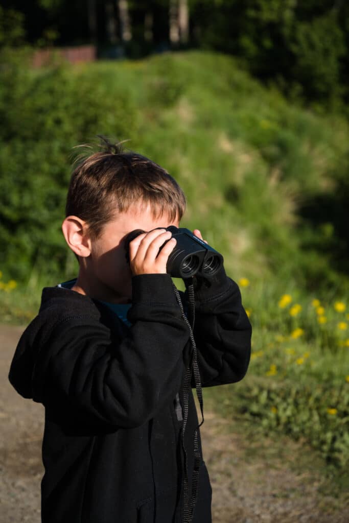 son using binoculars in Alaska