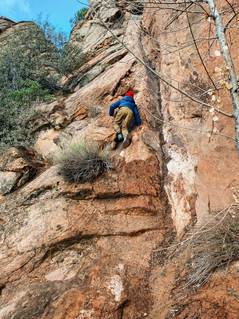 boy climbing rocks on Canyon Overlook Trail