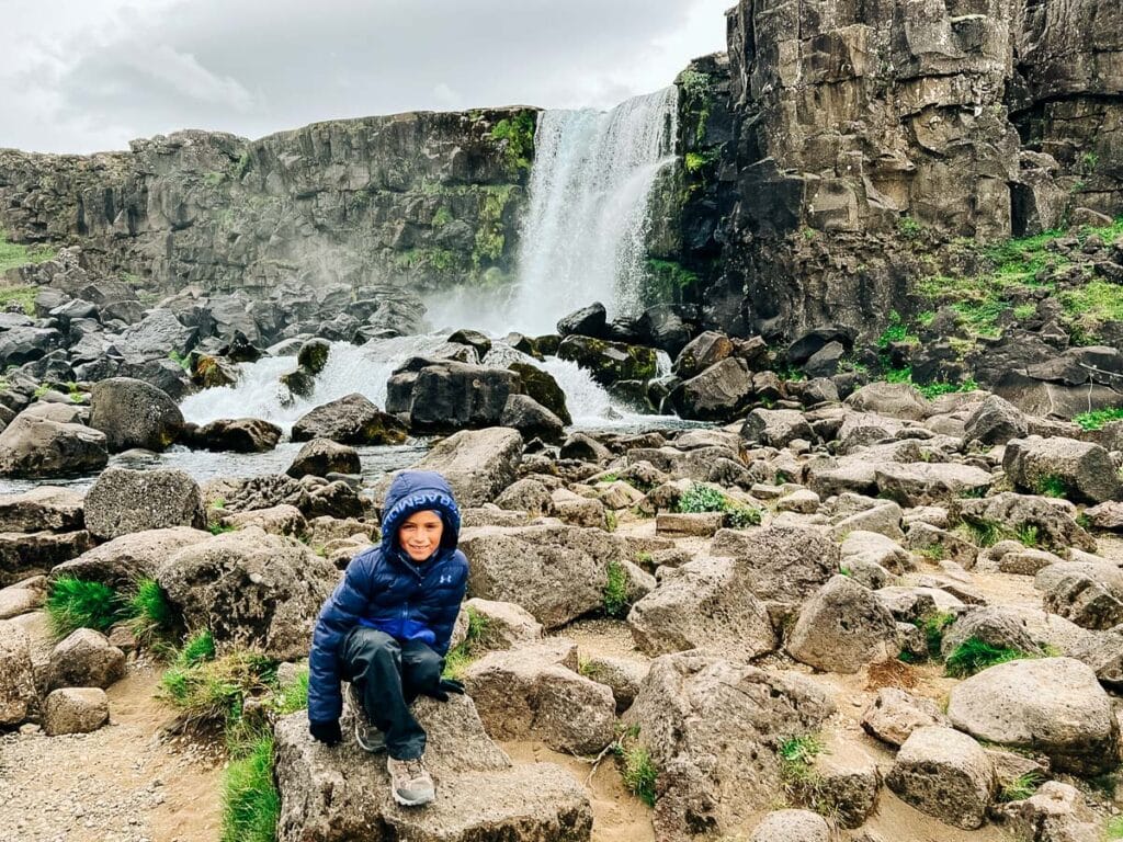 my son at Thingvellir National Park in front of the waterfall