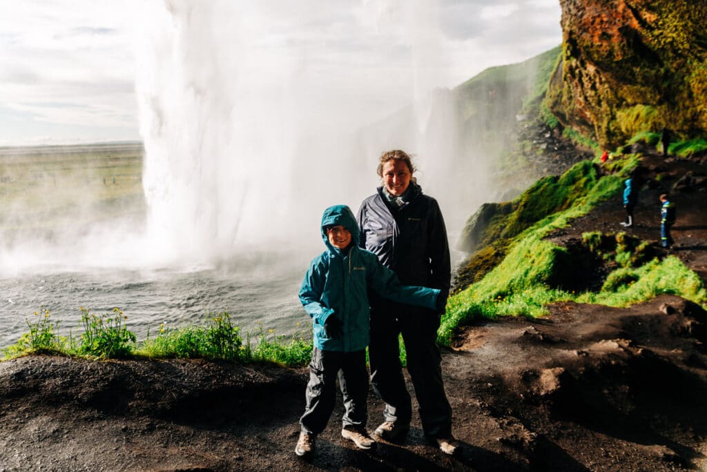 me and my son getting soaked behind a waterfall in Iceland