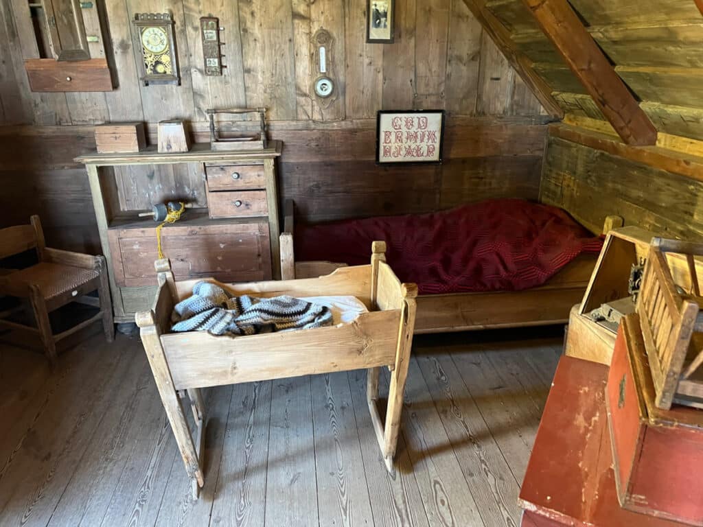 Staged bedroom inside one of the model houses at Skogar Museum