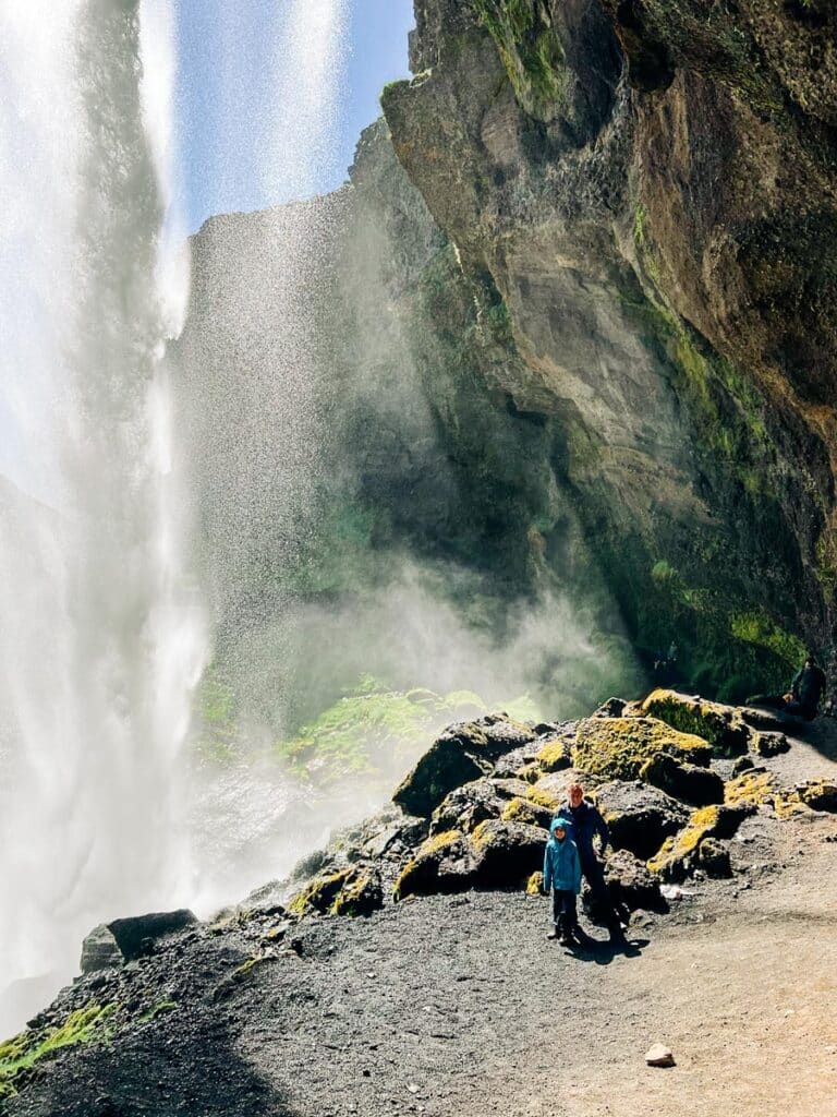 Walking behind Kvernufoss Waterfall