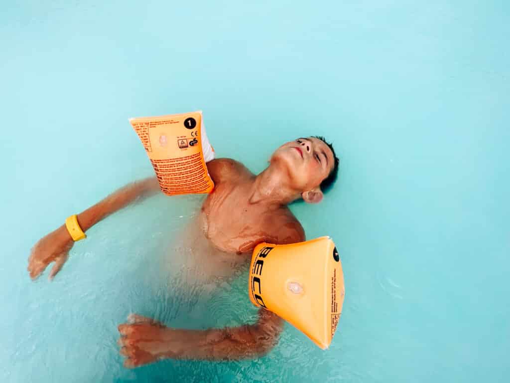 my son floating in the blue water at Blue Lagoon in Iceland