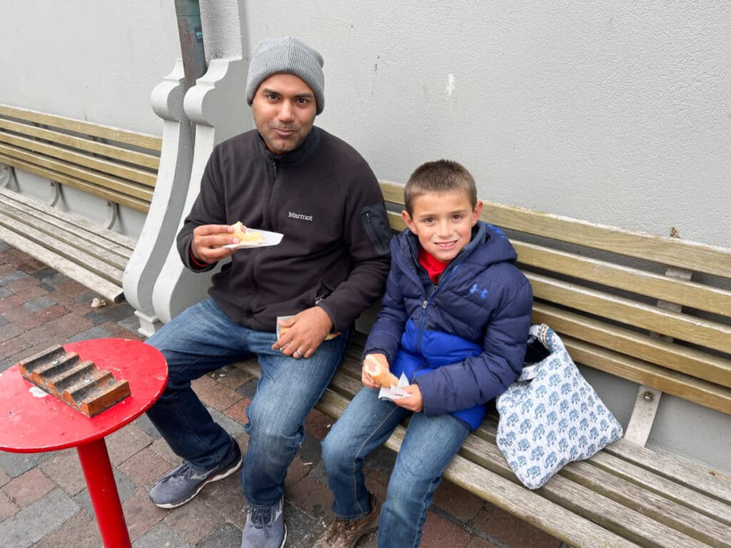 My husband and son eating hot dogs in Reykjavik.