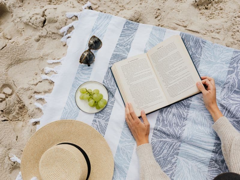 a book on a blanket at the beach