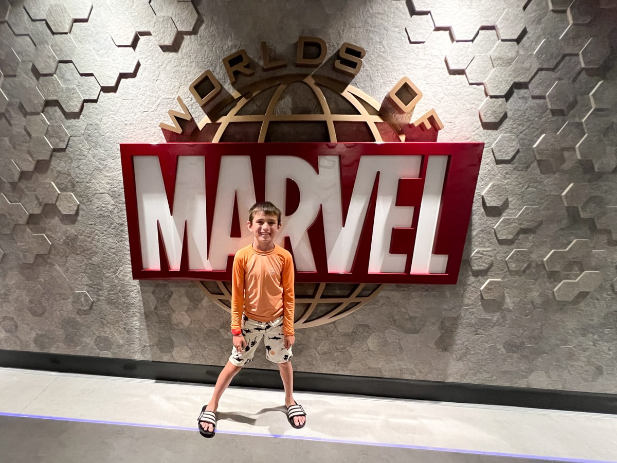 my son in front of the Marvel restaurant on Disney Wish