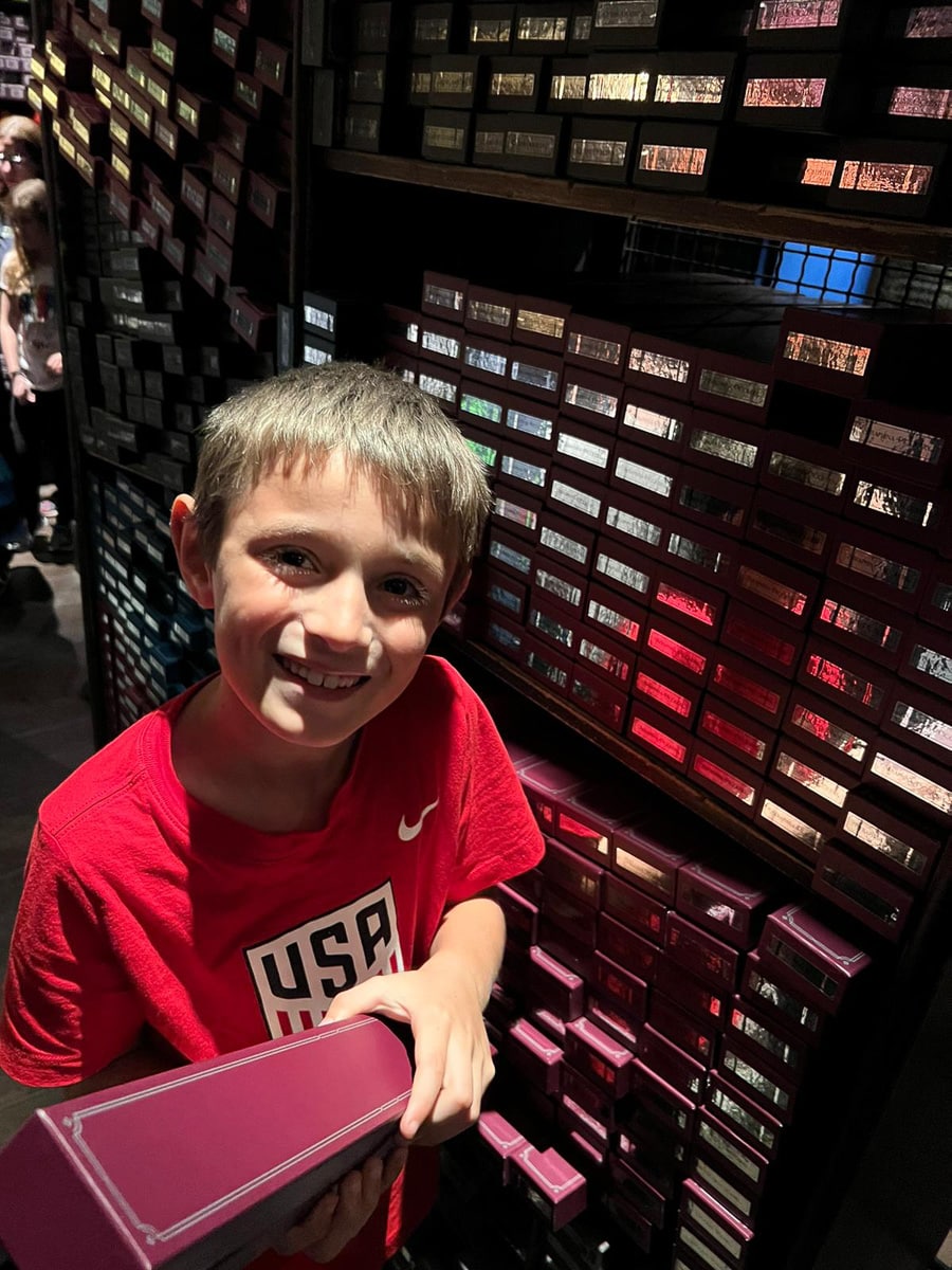 my son picking out his wand at Ollivander's at Universal Studios