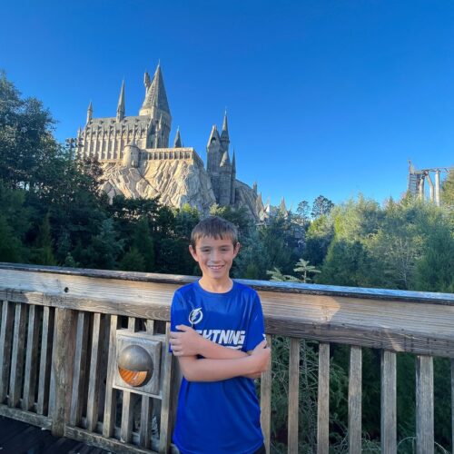 my son at universal studios in front of Hogwart's