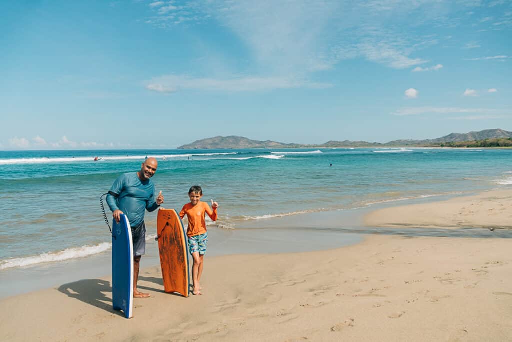 my husband and son with boogie boards in Tamarindo, Costa Rica