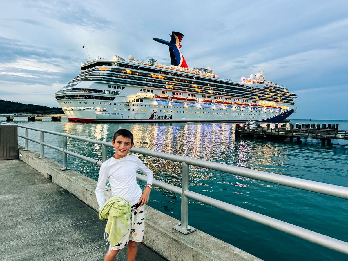 my son in front of the Carnival Freedom cruise ship