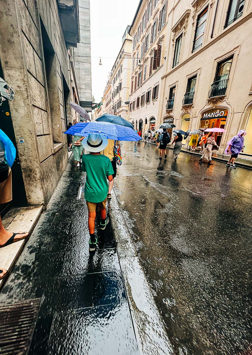 my son with an umbrella in the rain in Rome