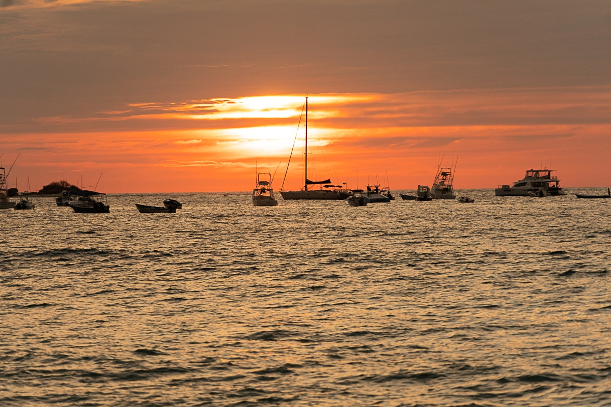 boats in the water at sunset in Tamarindo