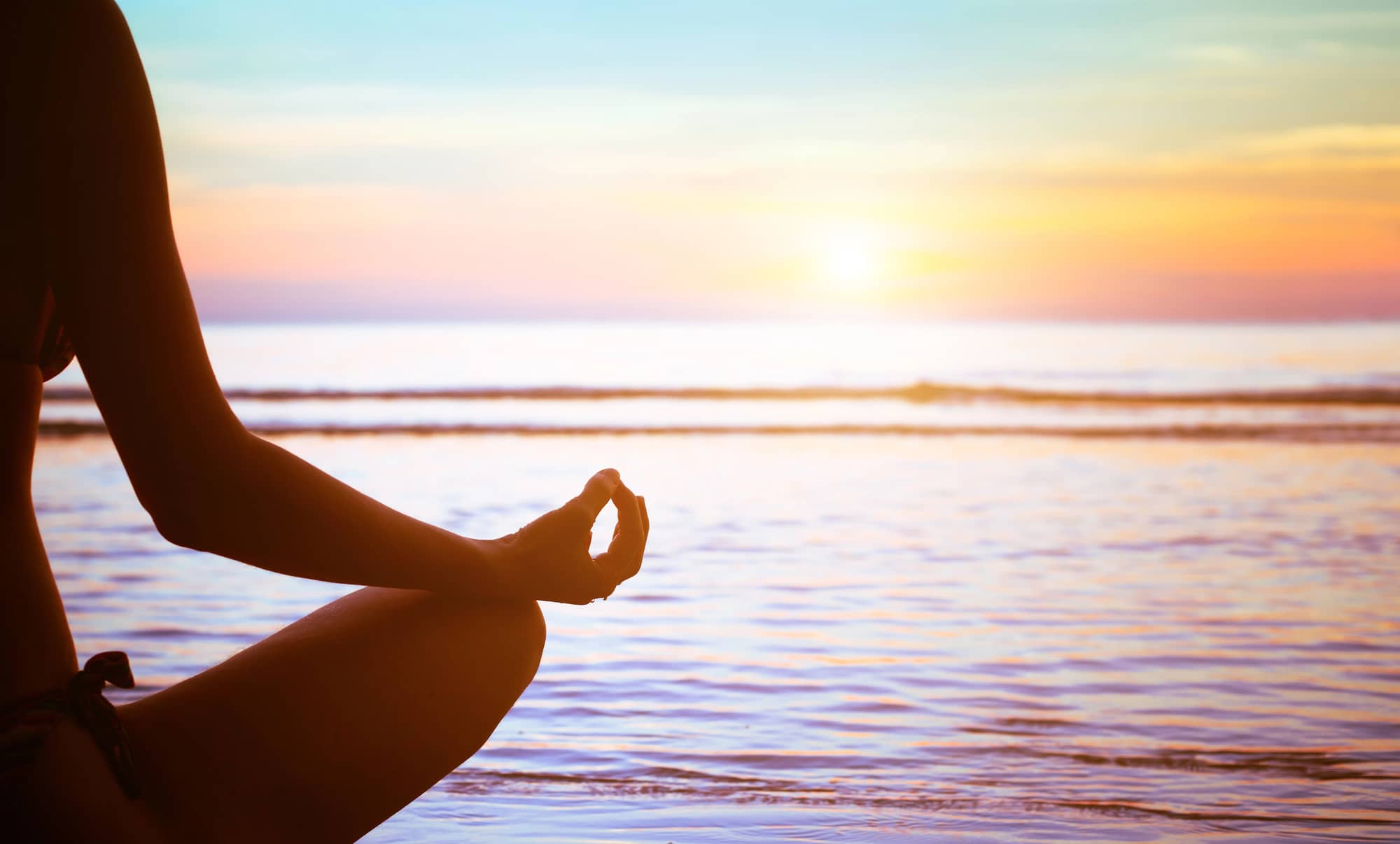 woman doing yoga on the beach