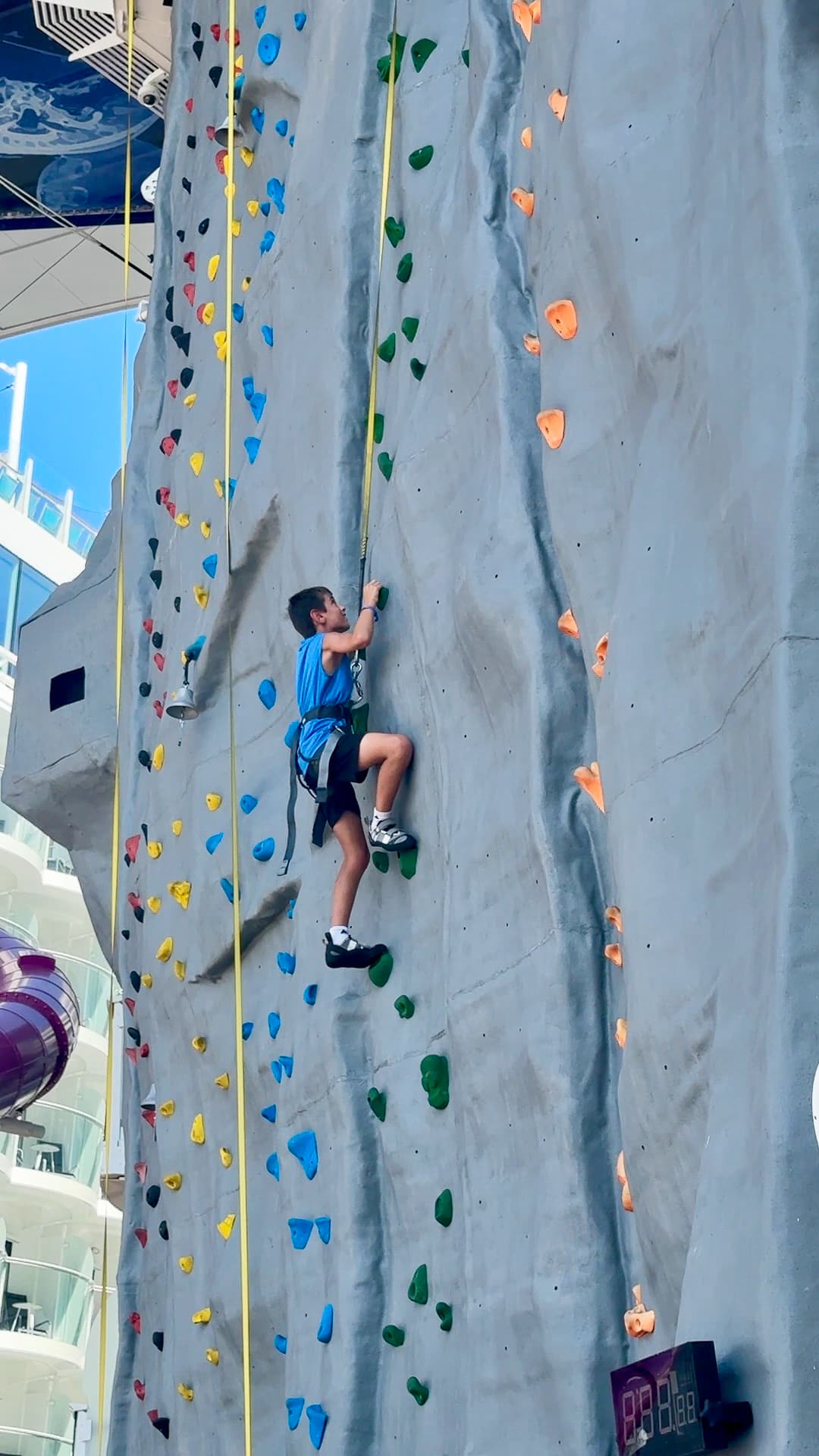 my son climbing the rock wall on Utopia of the Seas