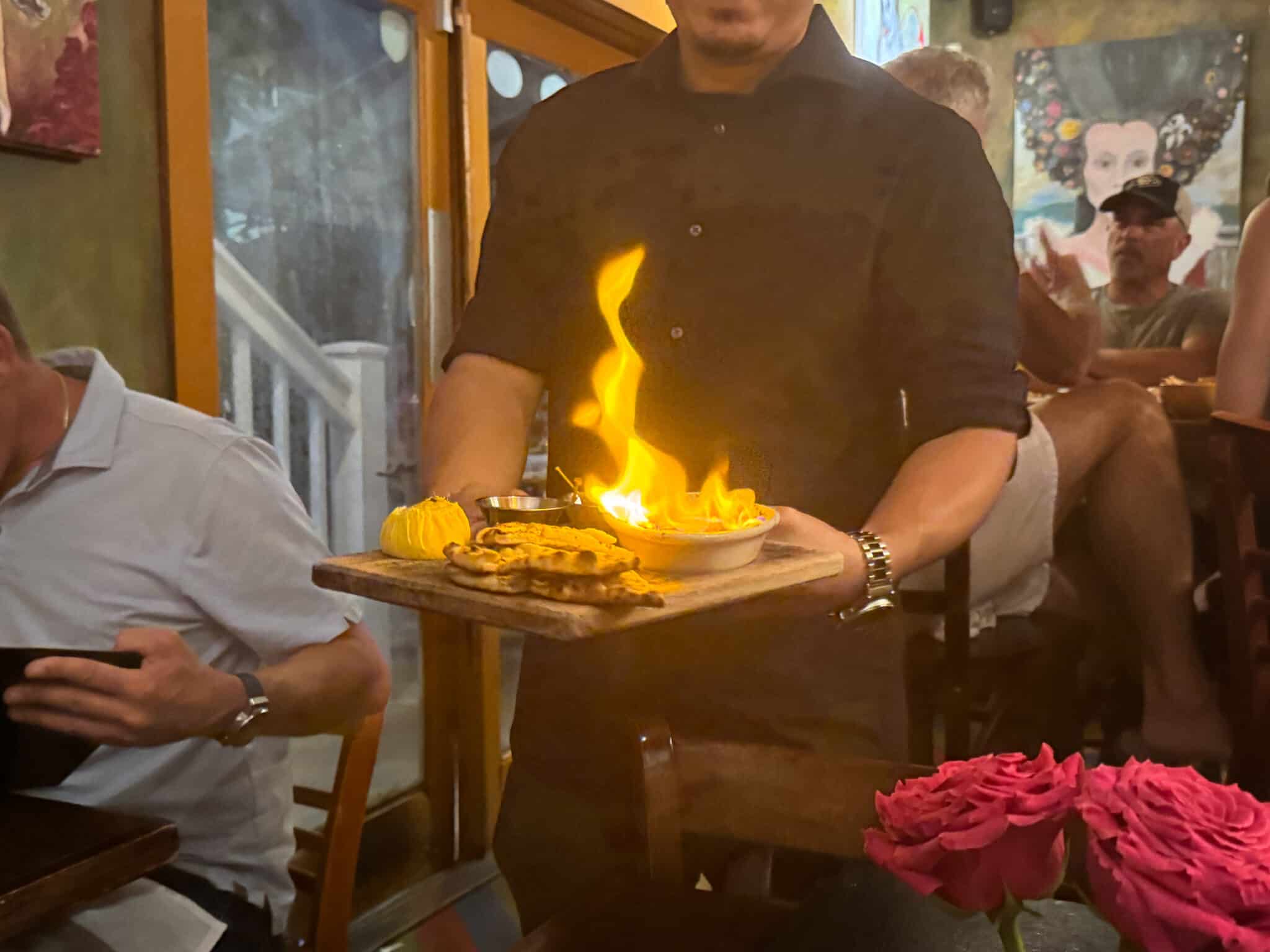server bringing the flaming saganaki to our table