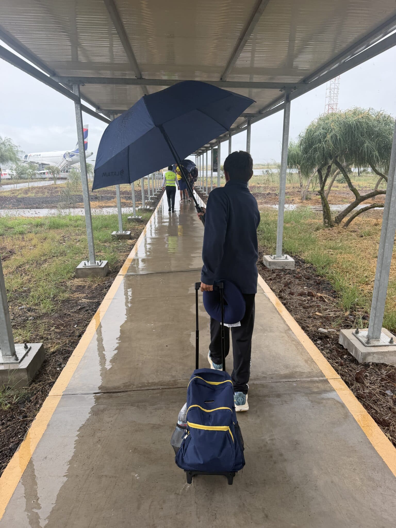 my son with an umbrella at baltra airport
